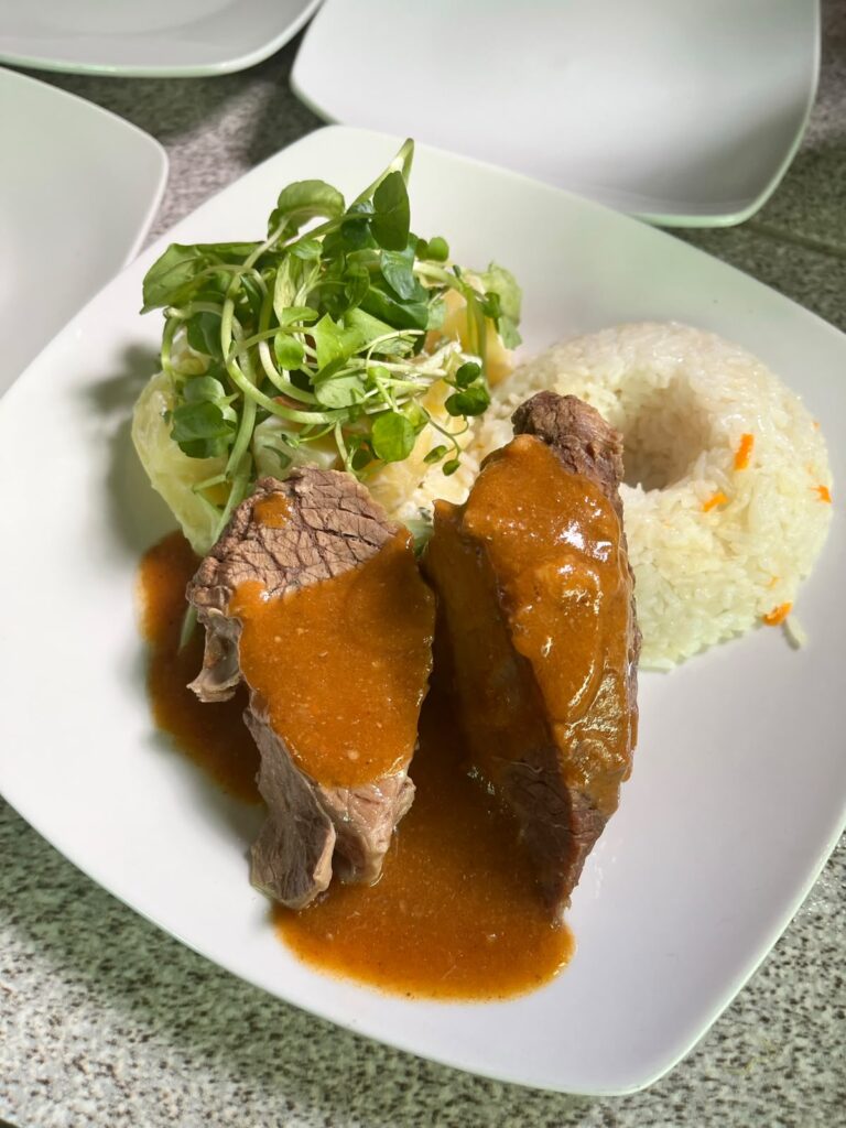 Plato de carne con arroz y ensalada en Kaas Eventos