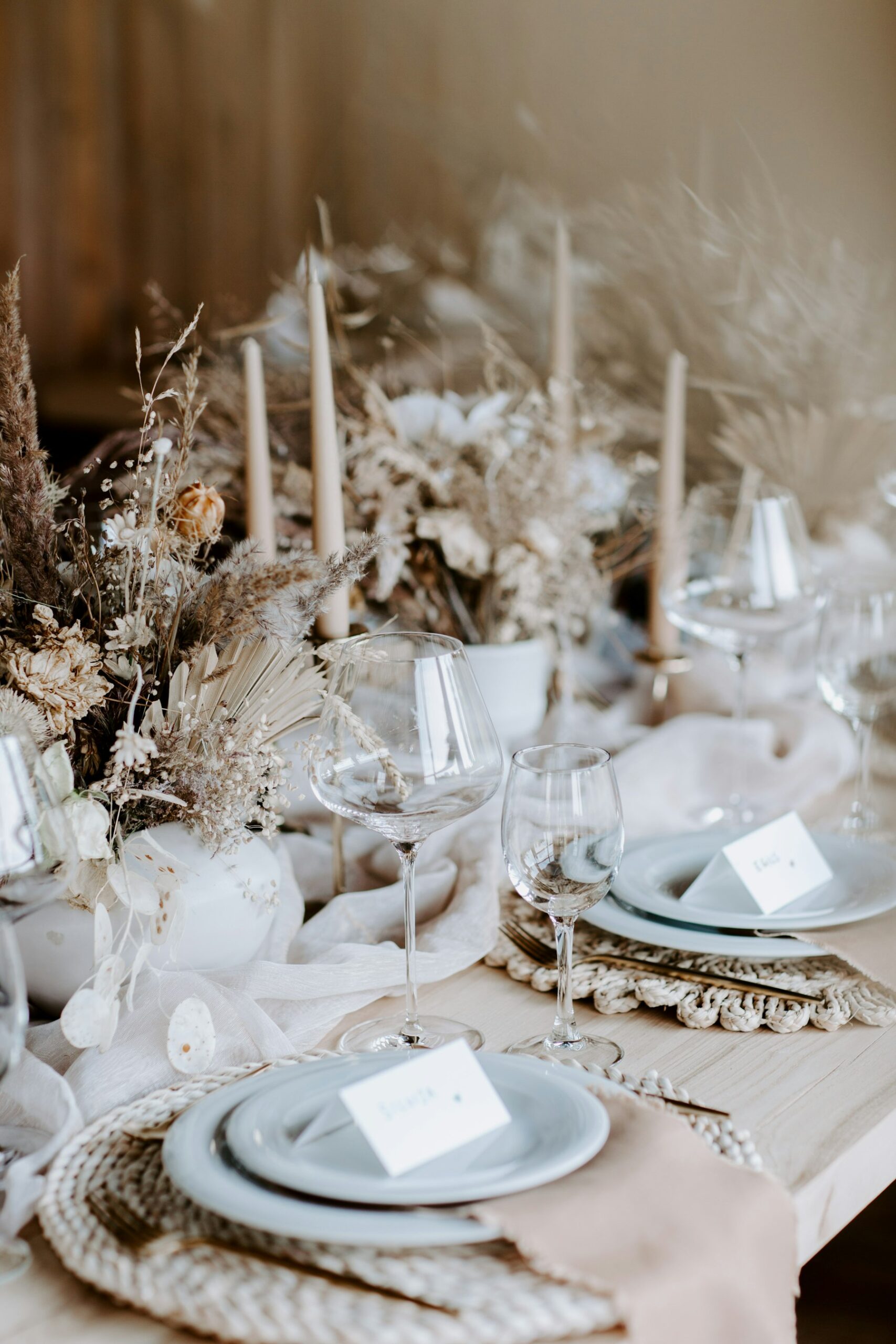Mesa de matrimonio con vajilla, velas y flores en tonos neutros