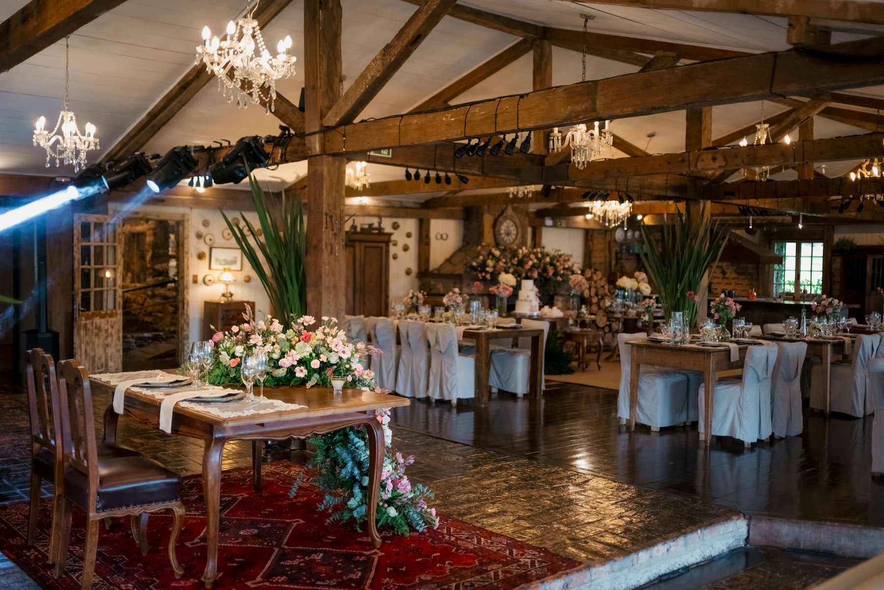 Salón con vigas de madera y mesas preparadas