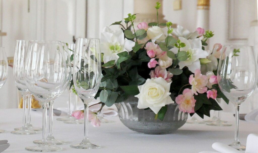 Arreglo floral en tonos pastel junto a copas
