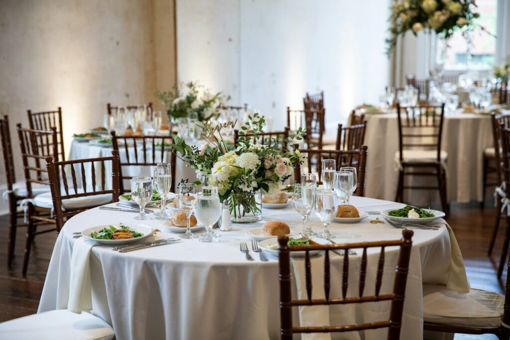 Mesas redondas con mantel y centros florales en un salón