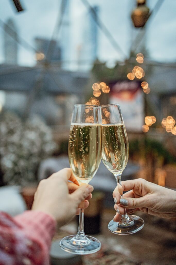 Copas de champaña en un brindis con luces cálidas